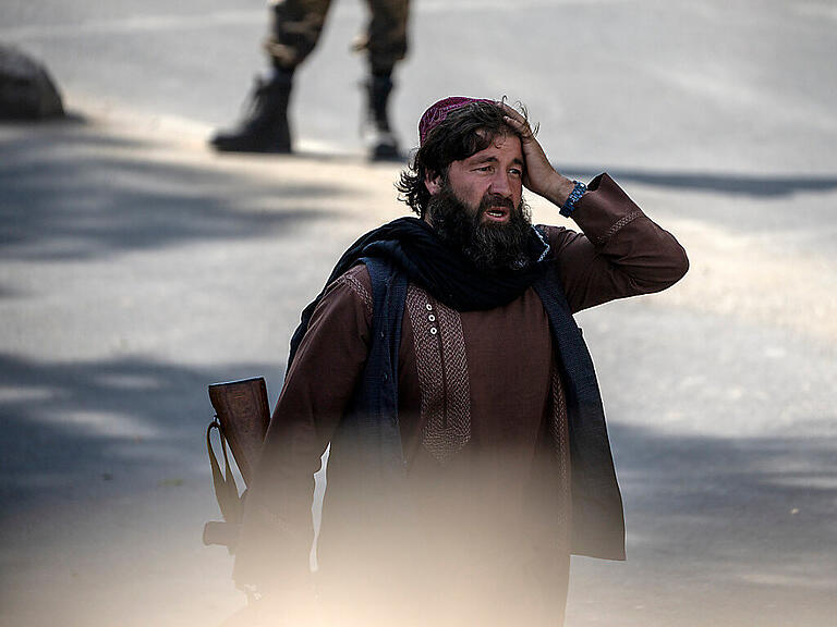 Ein schockierter Taliban-Kämpfer steht am Explosionsort und hält sich die Hand an den Kopf. Foto: Ebrahim Noroozi/AP/dpa