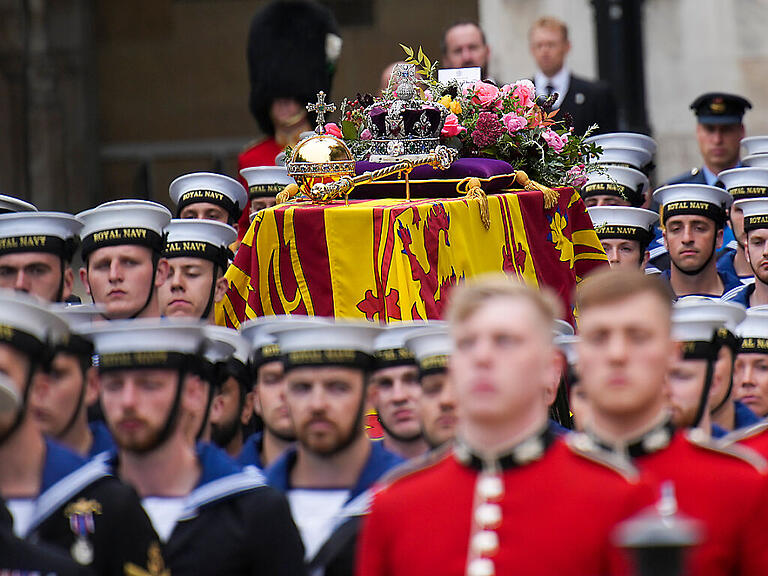 Der Sarg von Königin Elizabeth II. wird auf eine Lafette gestellt und in einer Prozession in die Westminster Abbey zum Staatsakt vor der Beisetzung von Königin Elizabeth II. gebracht. Foto: Emilio Morenatti/Pool AP/dpa