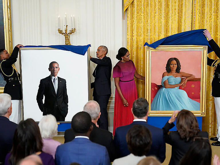 Barack Obama (Mitte l), ehemaliger Präsident der USA, und die ehemalige First Lady Michelle Obama (Mitte r) enthüllen ihre offiziellen Porträts im Weißen Haus während einer Zeremonie im East Room des Weißen Hauses. Foto: Andrew Harnik/AP/dpa