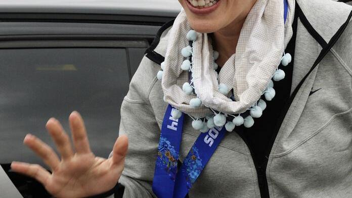 Goldmedaillengewinnerin Dominique Gisin strahlt nach ihrer Ankunft am Flughafen Zürich Kloten über das ganze Gesicht.