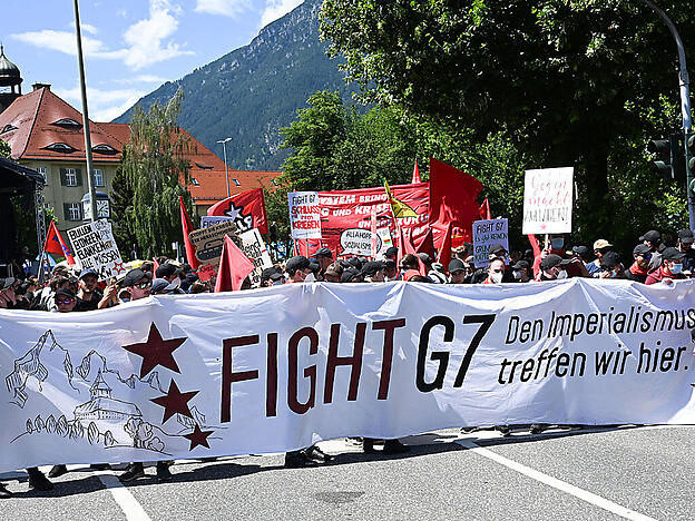 Menschen nehmen an einer Großdemonstration des Bündnisses «Stop G7 Elmau» in Garmisch-Partenkirchen teil. Zu Beginn des G7-Gipfels haben am Sonntagnachmittag Hunderte Menschen in Garmisch-Partenkirchen demonstriert. Die Polizei schätzte die Zahl auf 800. Foto: Angelika Warmuth/dpa