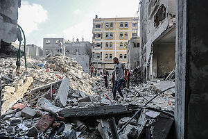 Palästinenser inspizieren die Trümmer eines Gebäudes, an dem der südliche Kommandeur des Islamischen Dschihads, Chalid Mansur, bei einem Luftangriff ums Leben gekommen ist. Foto: Mohammed Talatene/dpa