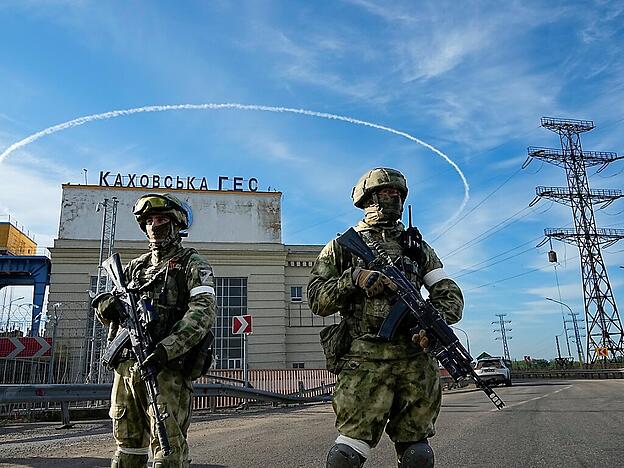 Zwei russische Soldaten bewachen einen Eingang des Wasserkraftwerks Kachowka. Foto: Uncredited/AP/dpa