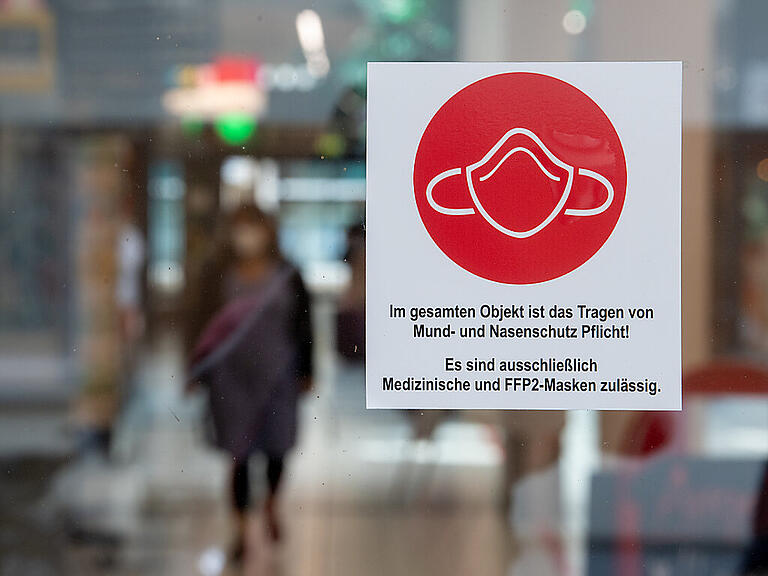 ARCHIV - Ein Schild am Eingang zu einer Einkaufspassage weist auf das Tragen von Mund- und Nasenschutz hin. Foto: Hendrik Schmidt/dpa-Zentralbild/dpa