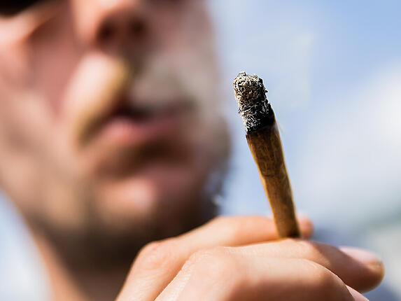 ARCHIV - Ein Mann raucht einen Joint mit Medizinalcannabis. Foto: Christoph Soeder/dpa