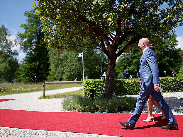 Charles Michel , Präsident des Europäischen Rates, geht mit seiner Partnerin Amelie Derbaudrenghien zum G7-Gipfel auf Schloss Elmau. Laut Michel sind die US-Vorschläge zur Durchsetzung einer Preisobergrenze für russisches Öl aus Sicht der EU noch nicht hundertprozentig überzeugend. Foto: Philipp von Ditfurth/dpa