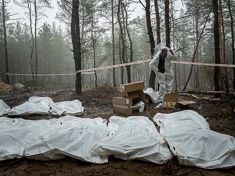 Säcke mit Leichen sind während der Exhumierung im kürzlich zurückeroberten Gebiet von Isjum, zu sehen. Foto: Evgeniy Maloletka/AP/dpa