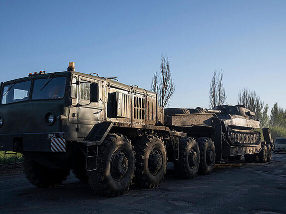 Ein Militärlastwagen transportiert ukrainische Panzerartillerie in der Region Donezk. Foto: Evgeniy Maloletka/AP/dpa/Archiv