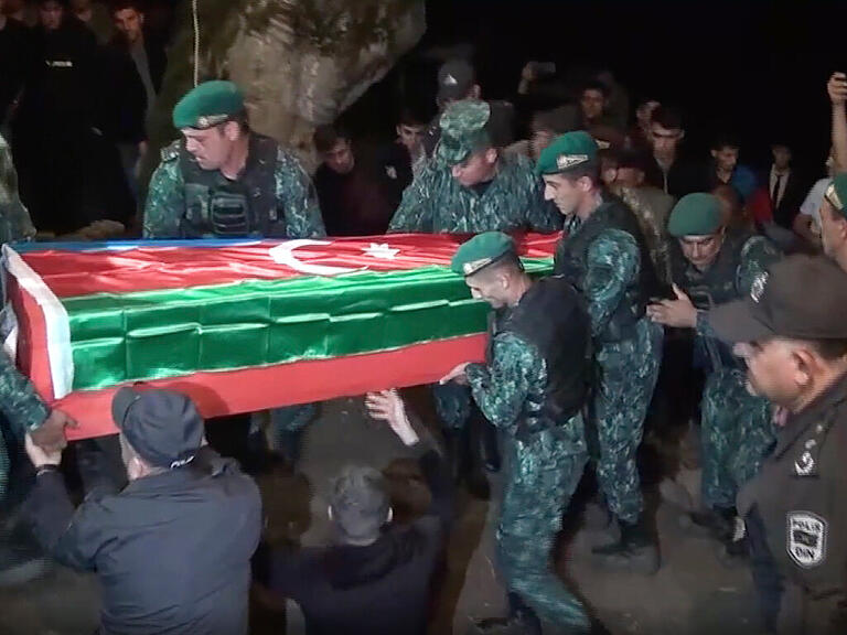 SCREENSHOT - In diesem Videostandbild tragen Soldaten den Sarg des an der aserbaidschanisch-armenischen Grenze getöteten aserbaidschanischen Soldaten S. Sadykhov während seiner Beerdigung. Foto: -/AP/dpa