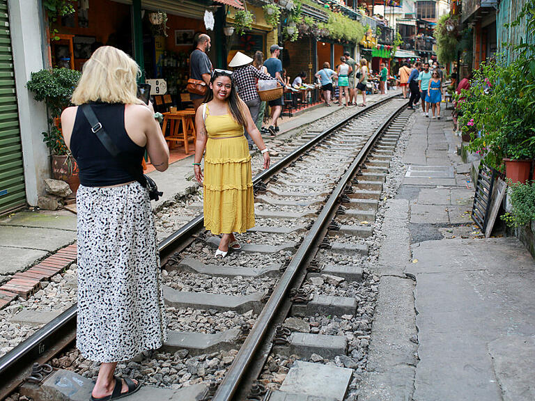 ARCHIV - Touristinnen machen Fotos für Instagram auf den Bahngleisen der berühmten «Train Street». Foto: Chris Humphrey/dpa